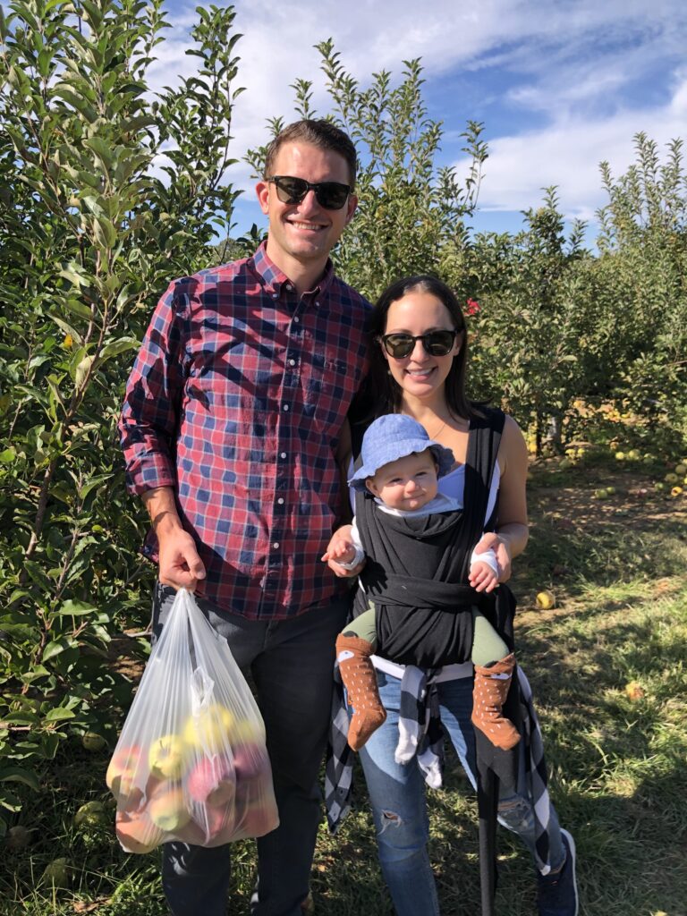 mom dad and baby apple picking outside